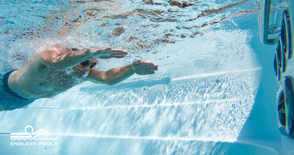 Man simmar under vattnet i ett swimspa